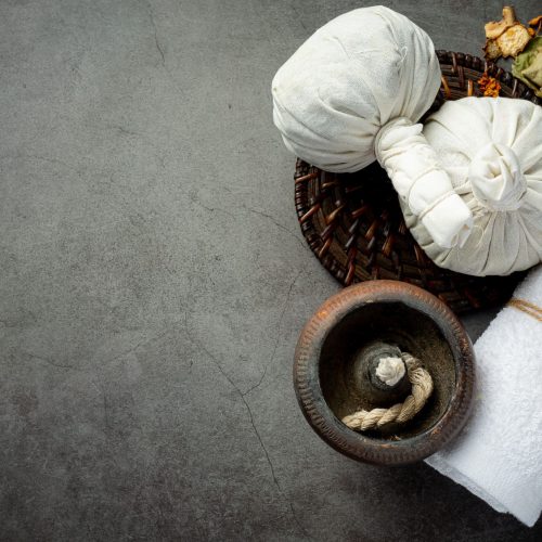 Herbal compress and herbal spa treatment equipments put on dark floor